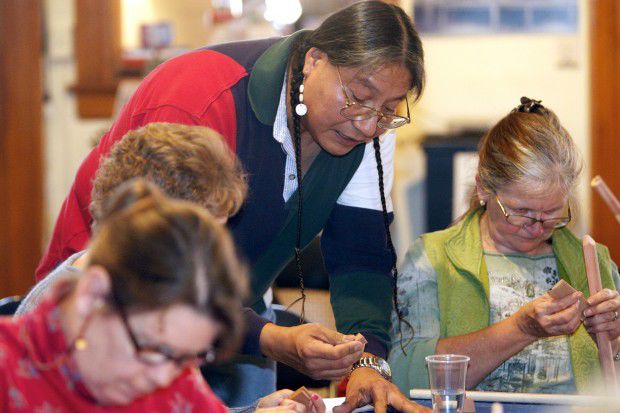 Flutist Joseph FireCrow helps people with their flutes
